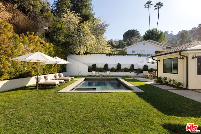 view of swimming pool with a yard