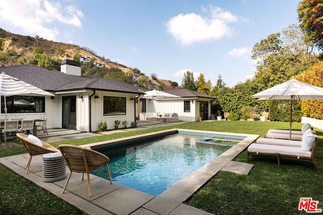 view of swimming pool featuring an in ground hot tub, a yard, and a patio