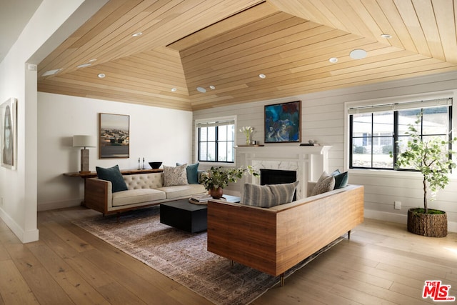 living room featuring hardwood / wood-style flooring, a premium fireplace, vaulted ceiling, and wood ceiling