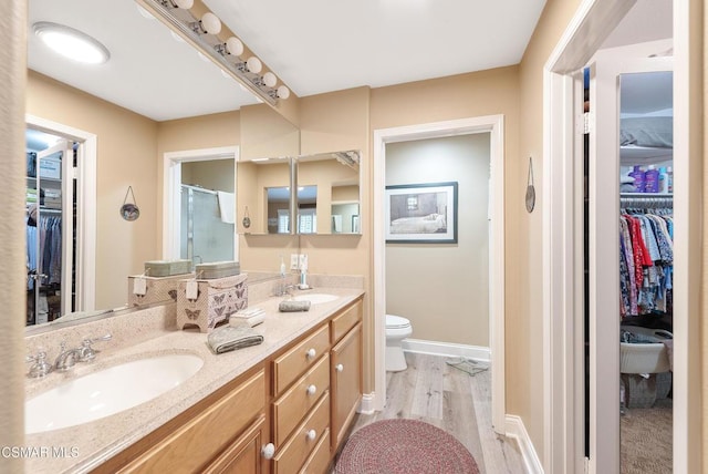 bathroom with vanity, hardwood / wood-style floors, toilet, and walk in shower