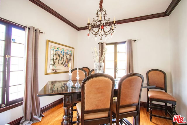 dining area featuring crown molding, an inviting chandelier, and light hardwood / wood-style floors