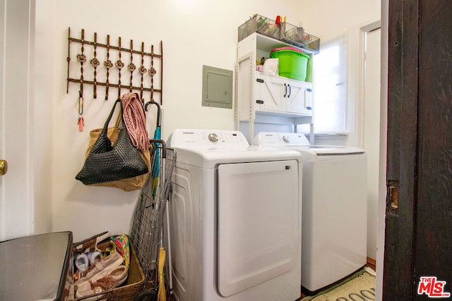 washroom featuring washer and clothes dryer, electric panel, and cabinets