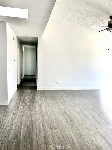 unfurnished room featuring hardwood / wood-style flooring, a textured ceiling, and ceiling fan