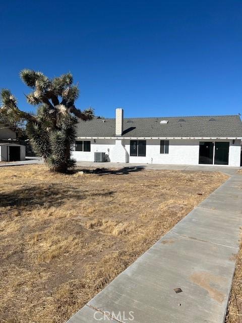 view of front of property with central AC unit and a front yard