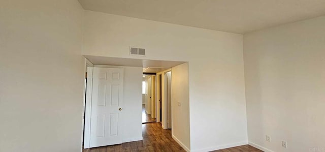 unfurnished room with dark wood-type flooring