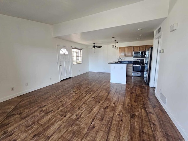 unfurnished living room featuring dark hardwood / wood-style floors, sink, and ceiling fan