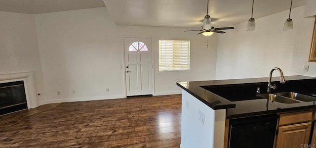 kitchen with dark wood-type flooring, sink, dark stone countertops, black dishwasher, and pendant lighting