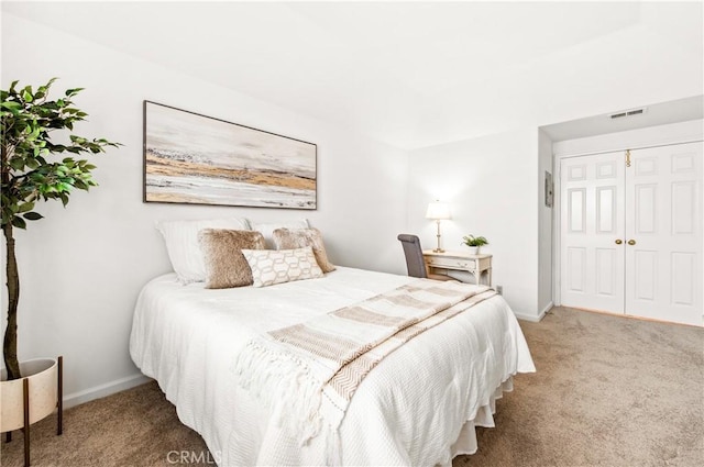 bedroom featuring carpet floors, a closet, visible vents, and baseboards