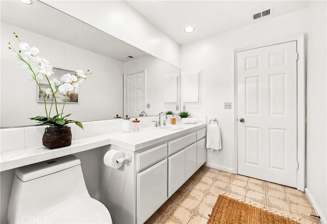 bathroom with visible vents, vanity, and baseboards