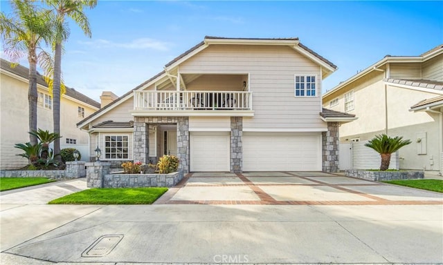 traditional home featuring a garage, stone siding, driveway, and a balcony