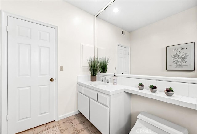 bathroom with toilet, baseboards, visible vents, and vanity