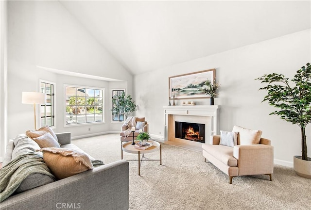 carpeted living area featuring a fireplace with flush hearth, high vaulted ceiling, and baseboards