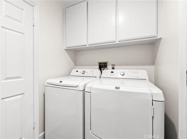 washroom featuring cabinet space and washer and clothes dryer