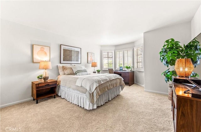 bedroom with light carpet and baseboards