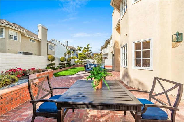 view of patio / terrace featuring outdoor dining area, fence, and a residential view