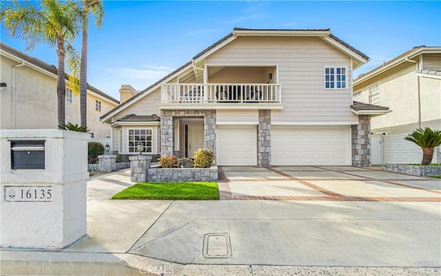 view of front of property featuring driveway, a garage, a balcony, stone siding, and fence