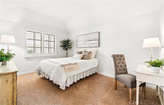 carpeted bedroom featuring lofted ceiling and baseboards