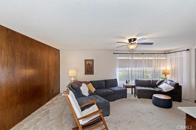 carpeted living room with a textured ceiling and ceiling fan