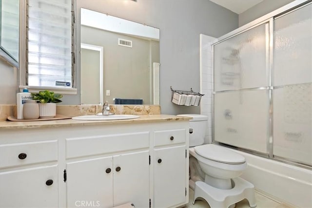 full bathroom with vanity, enclosed tub / shower combo, and toilet