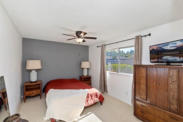 carpeted bedroom featuring ceiling fan and a textured ceiling