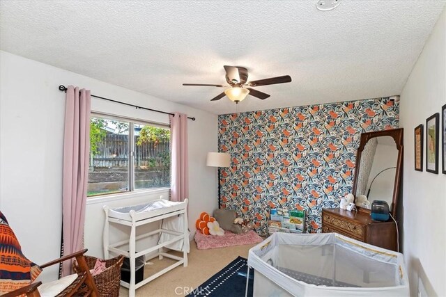 interior space featuring ceiling fan, carpet floors, and a textured ceiling