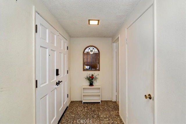 hallway with a textured ceiling