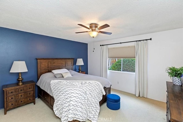 carpeted bedroom with ceiling fan and a textured ceiling