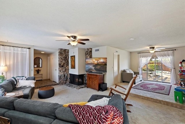 carpeted living room with ceiling fan and a textured ceiling