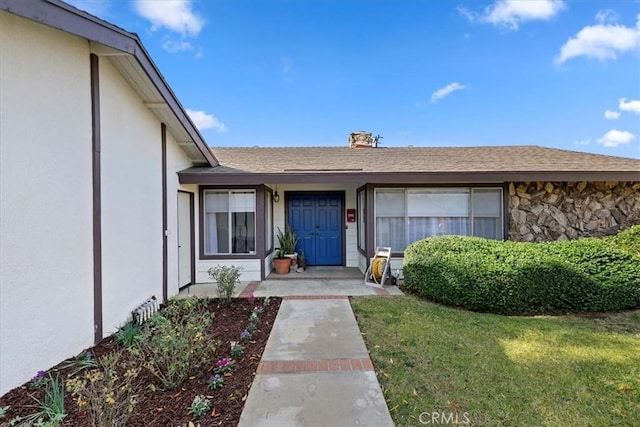 entrance to property featuring a yard