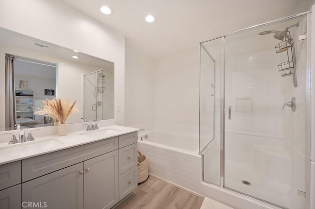 bathroom featuring vanity, plus walk in shower, and wood-type flooring