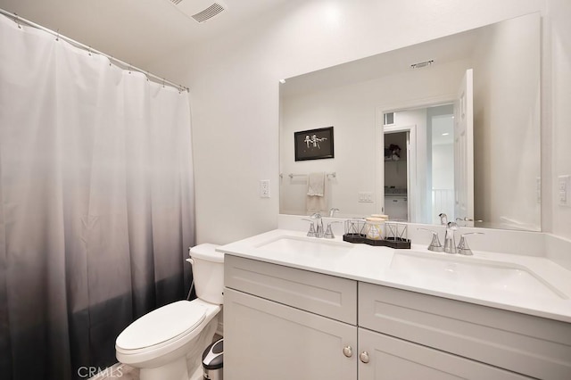 bathroom with vanity, curtained shower, and toilet