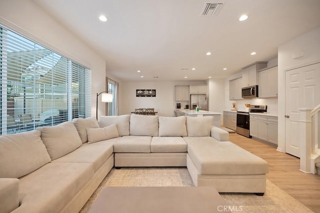 living room with a wealth of natural light and light hardwood / wood-style floors