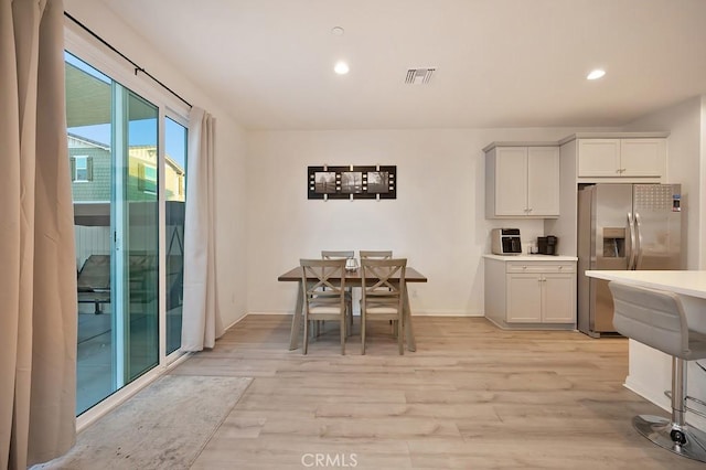 kitchen with white cabinetry, stainless steel fridge with ice dispenser, and light hardwood / wood-style floors