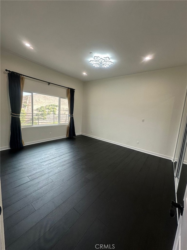 unfurnished room featuring dark hardwood / wood-style flooring