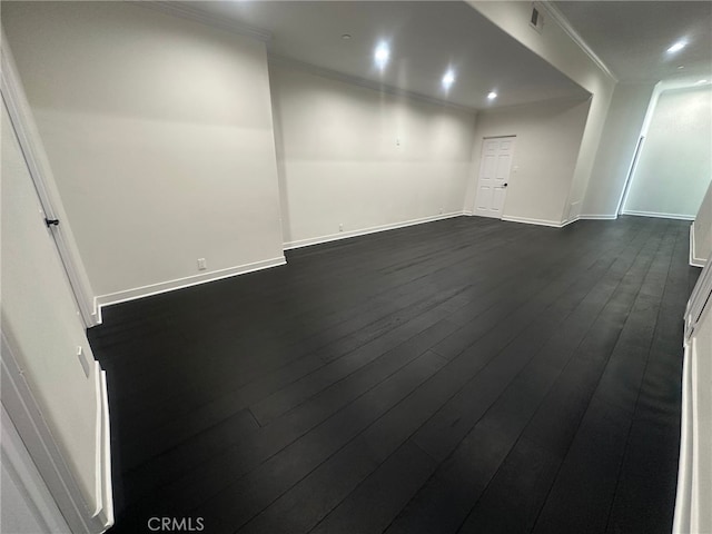 spare room with dark wood-type flooring and ornamental molding