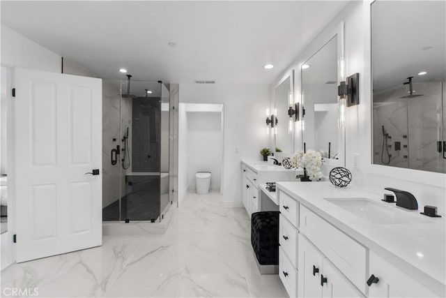 bathroom featuring vanity, toilet, and a shower with door