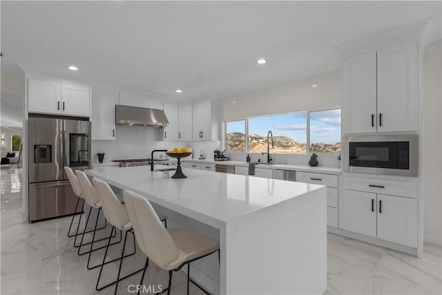 kitchen featuring sink, stainless steel appliances, a center island, and white cabinets