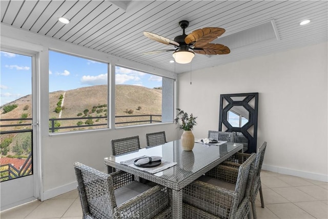 dining space with a mountain view, wood ceiling, a healthy amount of sunlight, and light tile patterned flooring