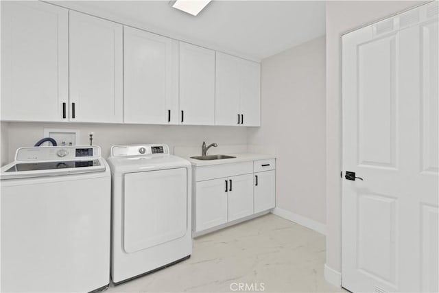 clothes washing area featuring cabinets, sink, and washing machine and dryer