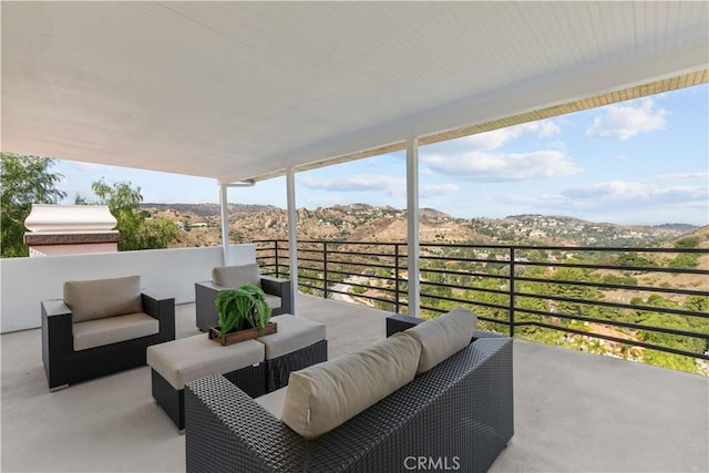 view of patio / terrace featuring a mountain view, an outdoor hangout area, and a balcony