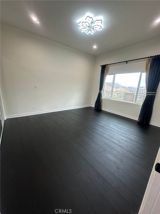 unfurnished room featuring dark hardwood / wood-style flooring