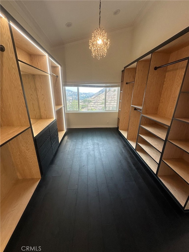 mudroom featuring crown molding, dark wood-type flooring, and an inviting chandelier