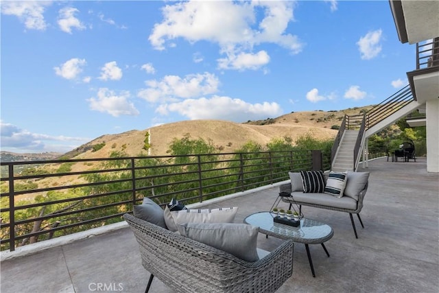 view of patio with a mountain view and a balcony