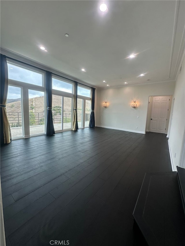 unfurnished living room with ornamental molding and dark wood-type flooring