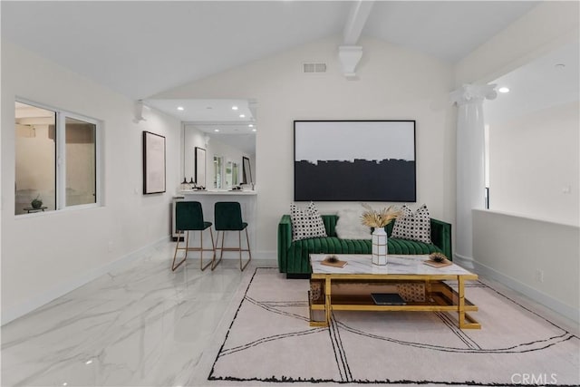 living room with decorative columns and vaulted ceiling with beams