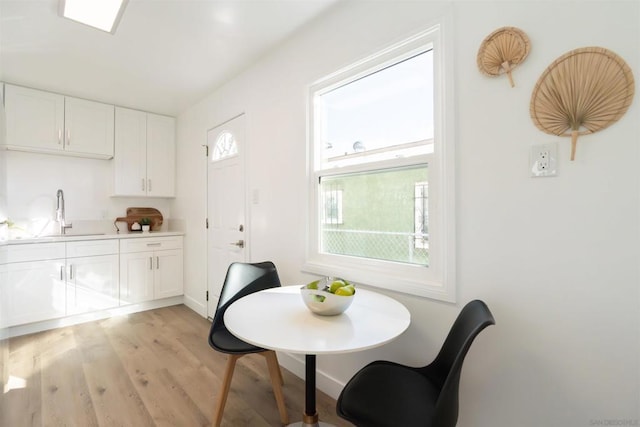 dining area with a healthy amount of sunlight, sink, and light wood-type flooring