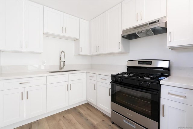 kitchen featuring white cabinetry, black range with gas cooktop, sink, and light wood-type flooring