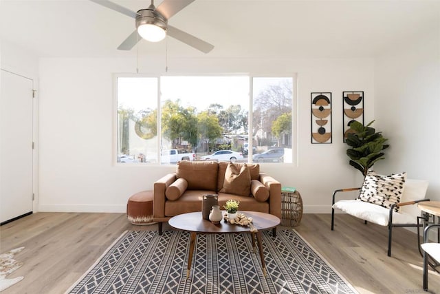 living room with light hardwood / wood-style flooring and ceiling fan