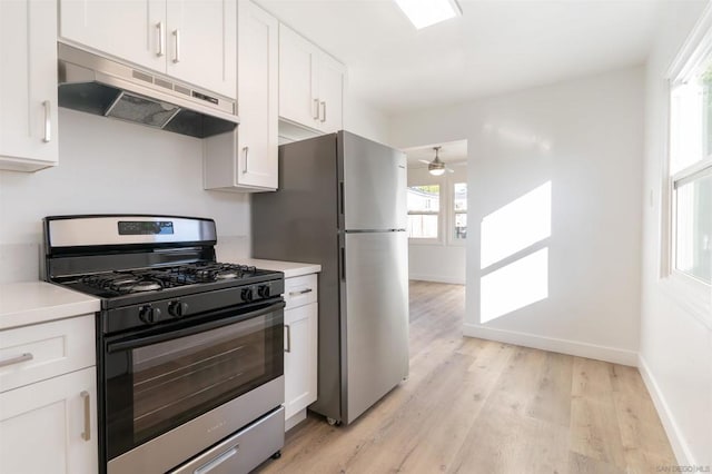 kitchen featuring stainless steel refrigerator, white cabinets, ceiling fan, light hardwood / wood-style floors, and gas range