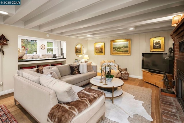 living room with beamed ceiling and light wood-type flooring